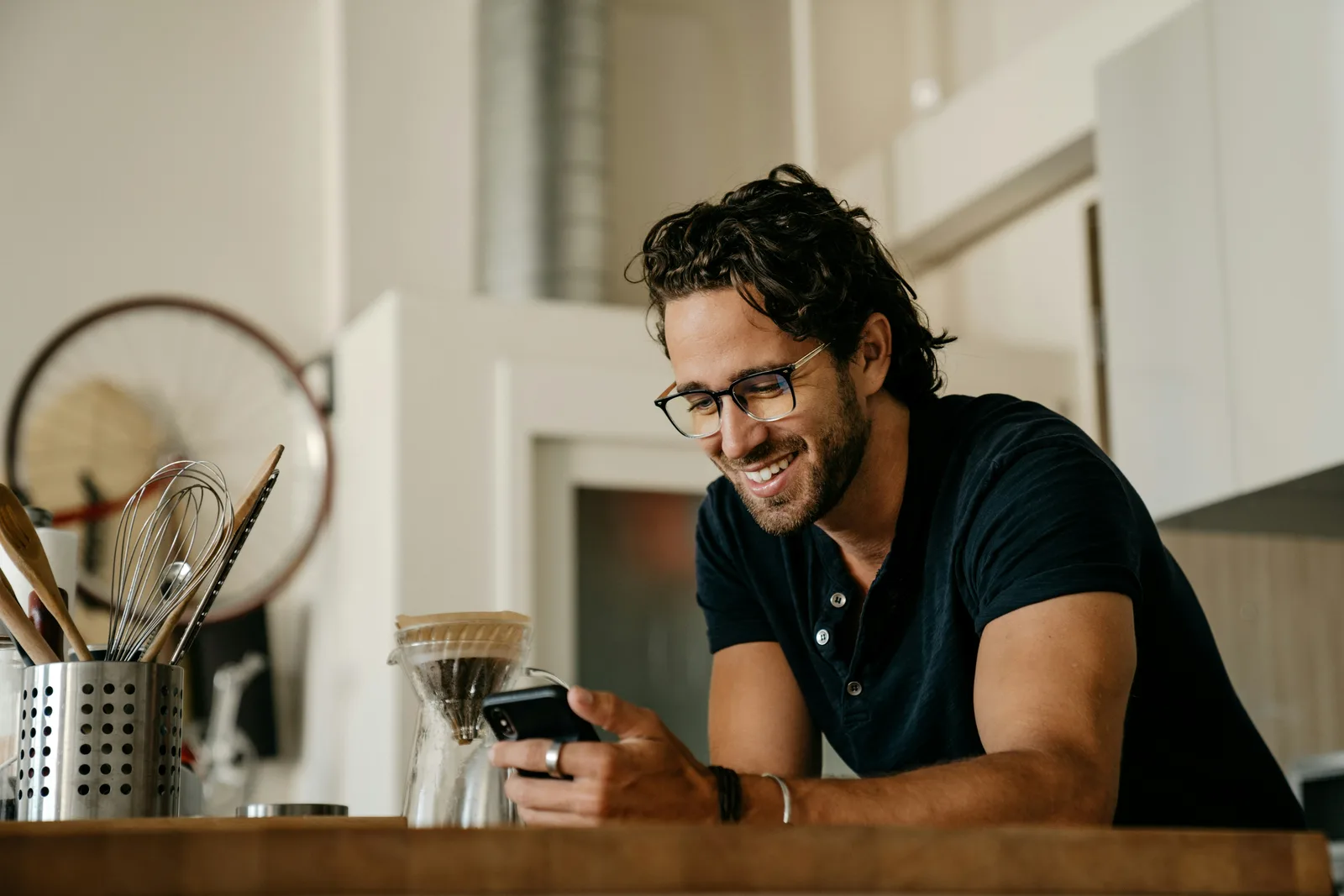 A customer smiling at their phone at home